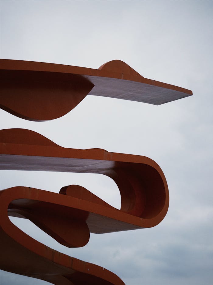 Modern abstract architecture with curved lines photographed against a cloudy sky.